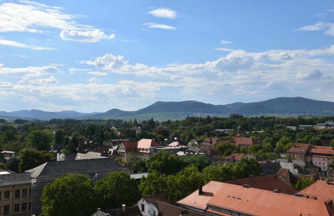 Aussicht auf die Dächer einer Stadt mit Bergen im Hintergrund