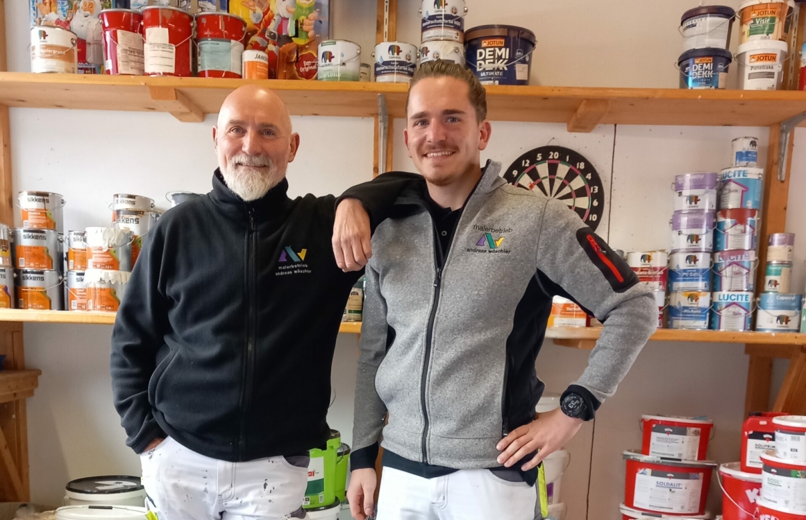 Zwei Maler stehen nebeneinander mit Arm auf Schulter des anderen