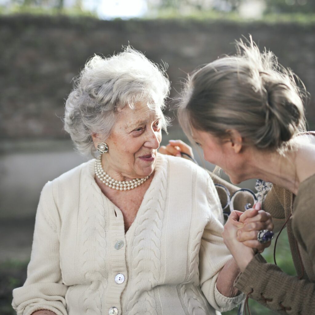 Seniorin unterhält sich mit einer jüngeren Frau