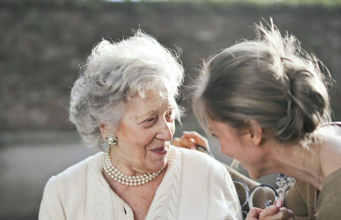Seniorin unterhält sich mit einer jüngeren Frau