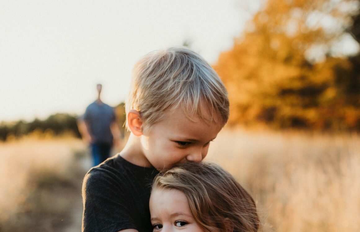 Kleiner Junge und kleines Mädchen umarmen sich liebevoll