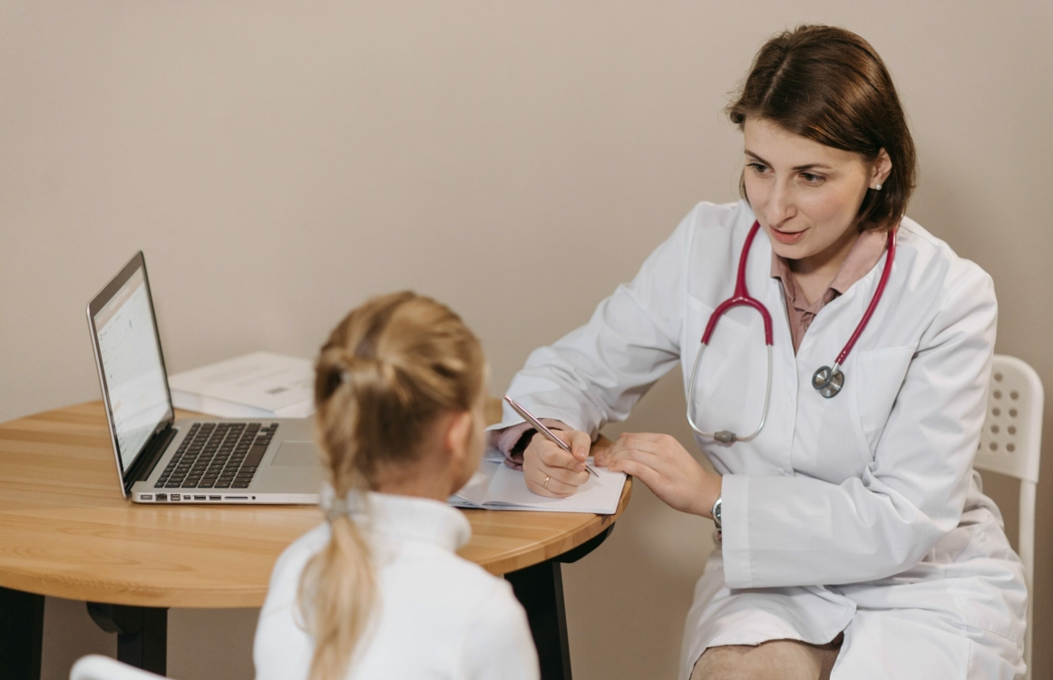 Ärztin mit Kind bei einer Untersuchung im Gespräch